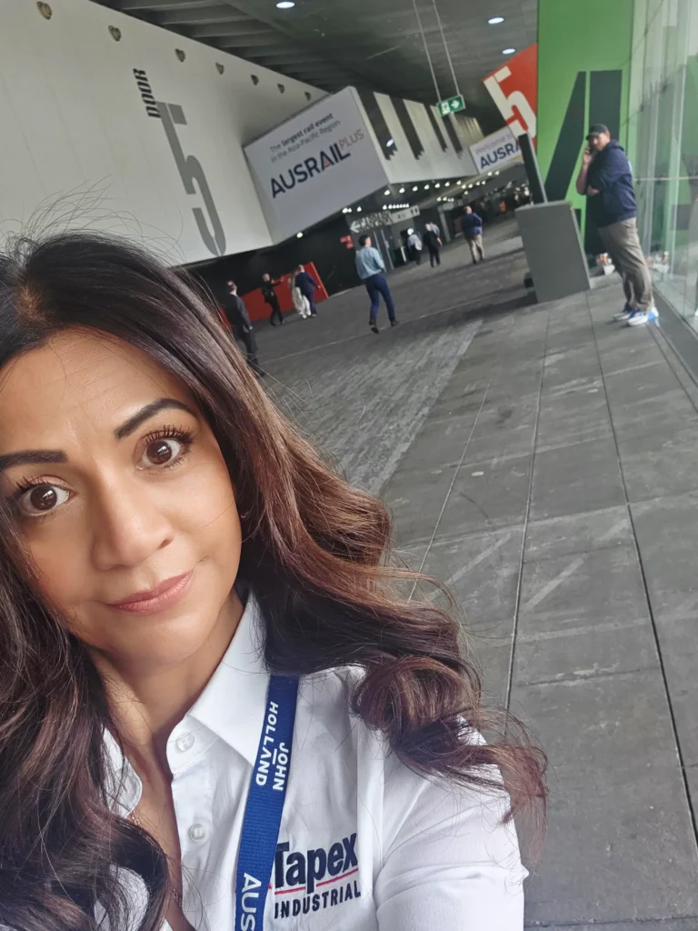 Michelle Moreira of Tapex Industrial outside Door 5 of the Melbourne Convention and Exhibition Centre at AusRAIL PLUS 2025.